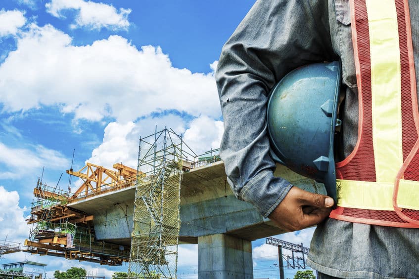 construction worker checking location site with crane on the background