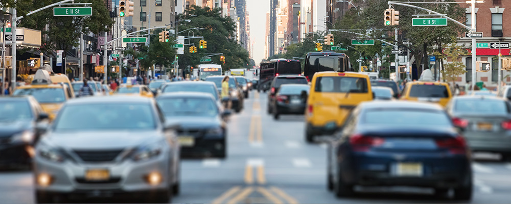 Heavy traffic moving through a busy New York City street corridor.