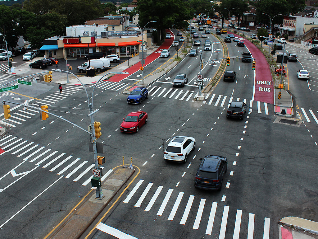 Vehicles traveling through a busy intersection in Queens, New York City.